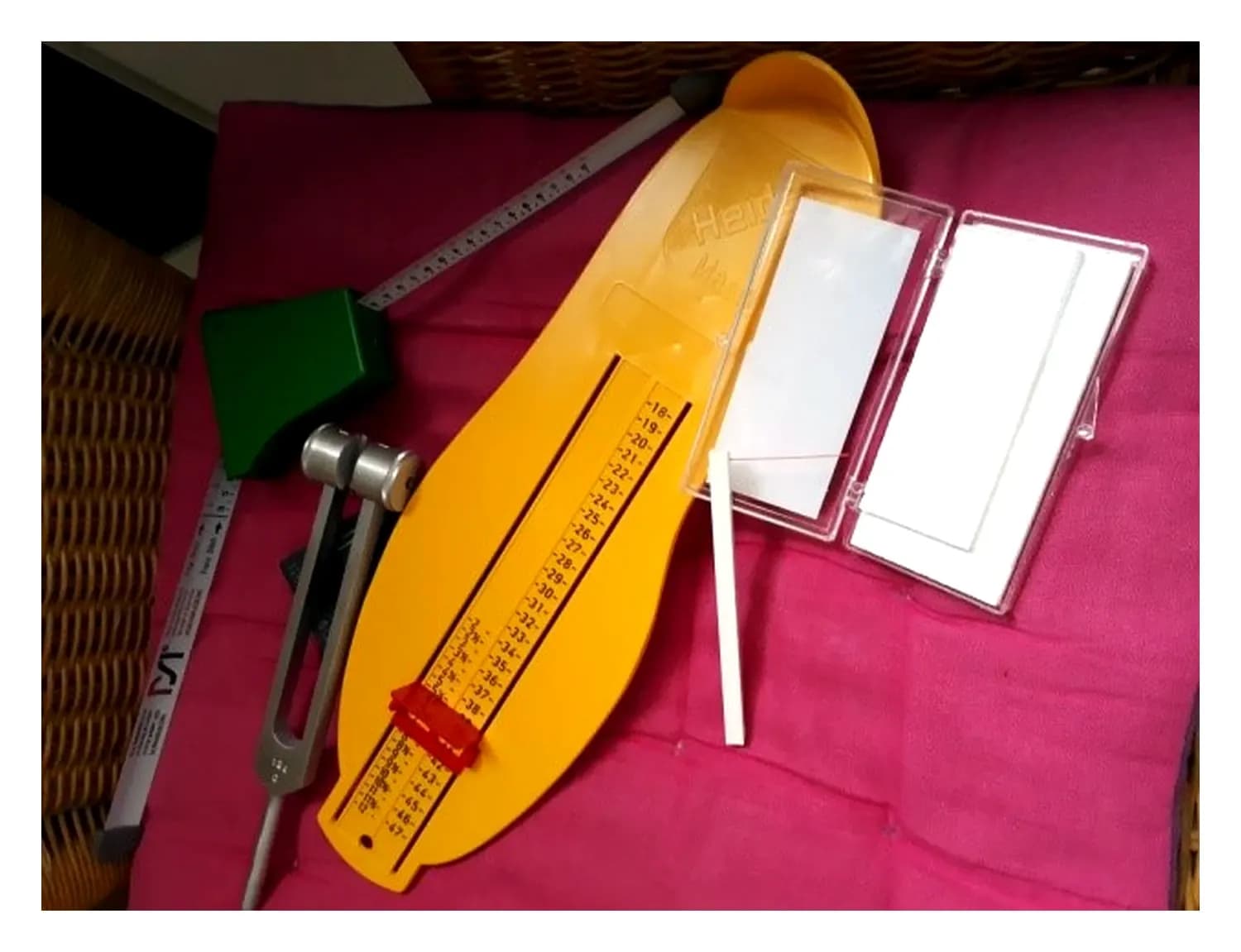 Meetgereedschap uit de praktijk: een voetmaatmeter, een rolmaat voor schoenen, een stemvork en een reflexhamer